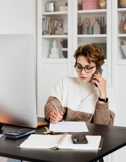 A smartphone displaying a vibrant wallpaper, surrounded by colorful stationery and a cozy workspace, ideal for productivity.