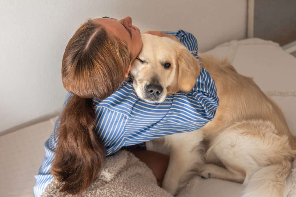 A teenage girl joyfully playing with her pet dog at home, highlighting the bond of emotional support animals for teens.