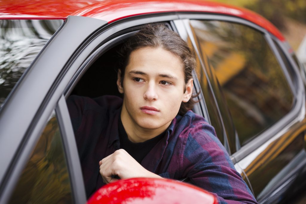 A new teen driver behind the wheel, focused on the road, highlighting safety challenges new teen drivers face.