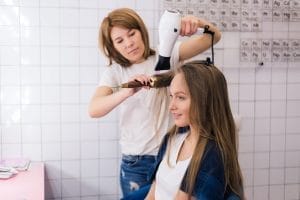 Teen girl having her hair styled in a salon