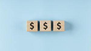 A visual representation of money, illustrating the cost of therapeutic treatment for teens, with coins and bills arranged cre