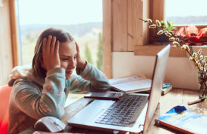 A worried schoolgirl doing homework at home, reflecting the theme of how to help my teen with math anxiety.