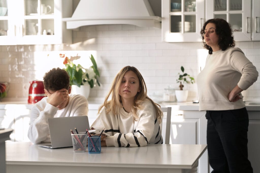 How a Working Parent Can Help a Struggling Teen 1 Mother and two teenagers at the kitchen table with a laptop