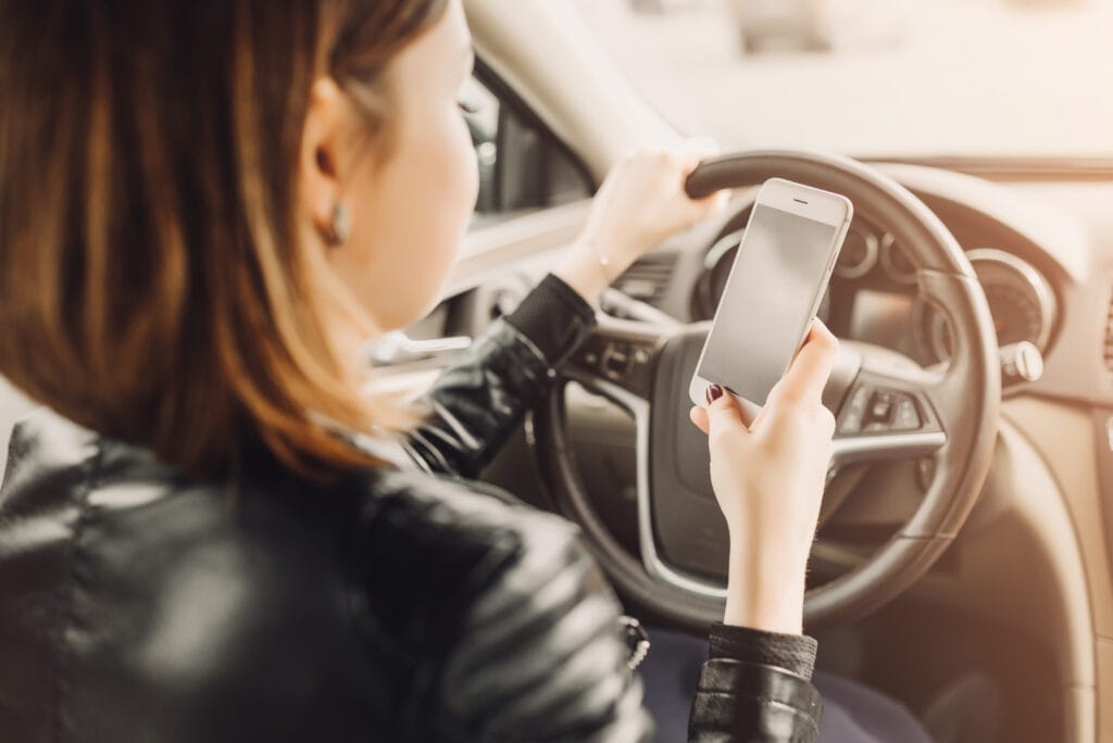 Teen Driving Safety: 7 Risks Parents Should Address Early 1 Young driver texting on a phone while holding the steering wheel
