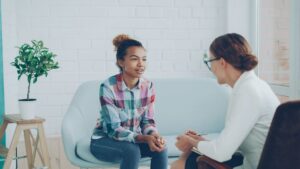A serene therapy session with a teenager discussing health challenges teens face, set in a calm and inviting room.