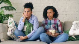 A frustrated teenager with crossed arms, reflecting feelings of teen anger towards mothers in a domestic setting.