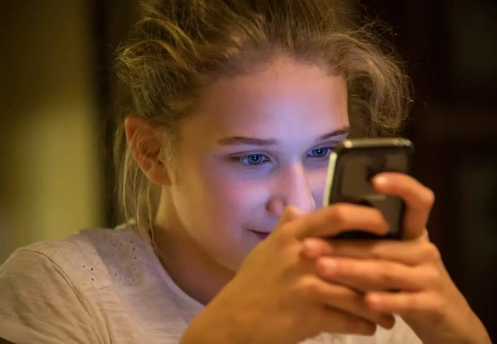 Online Safety Tips for Parents of Teens 5 Teenage girl looking at her smartphone at night