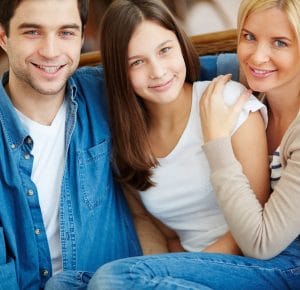 A diverse family engaging in a supportive discussion, illustrating how family dynamics affect teenage confidence.