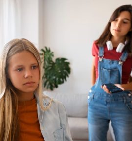 support troubled teens emotionally - A sad teenage girl sitting alone on a bench, reflecting on her emotions, symbolizing the