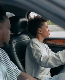 A teenager driving a car, symbolizing the transition to independence and responsibility when to get your teen their first car
