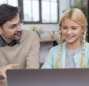 teach teenagers responsible technology use - A tutor guides a teenager in using a laptop for learning, emphasizing the import