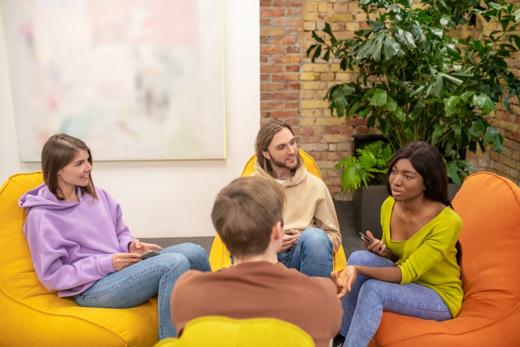 group young people sitting together discussing something